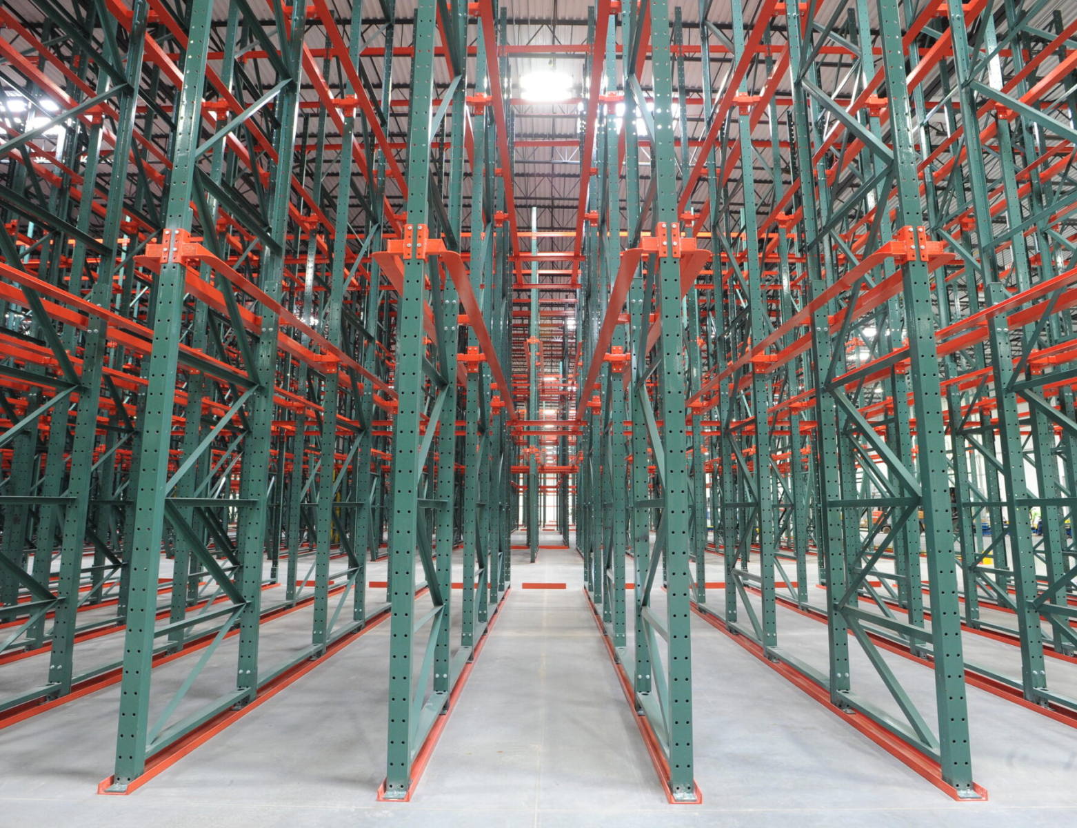 Pallet rack inspection — green and orange racking systems