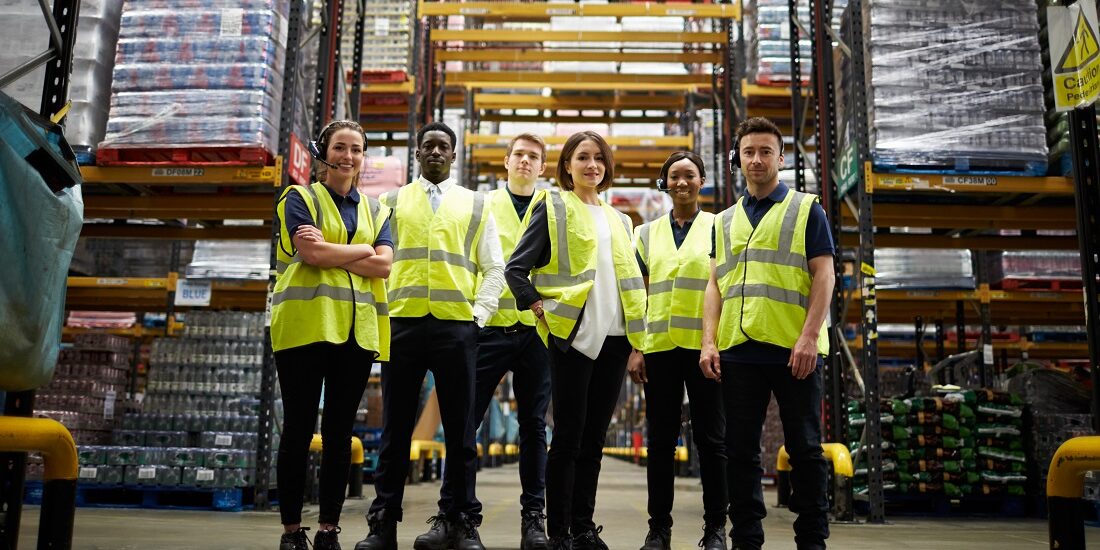 Group portrait of staff at distribution warehouse, low angle